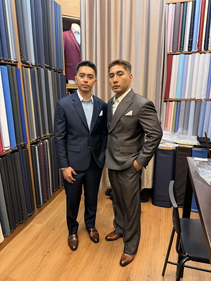 Two clients in coordinated navy and charcoal suits